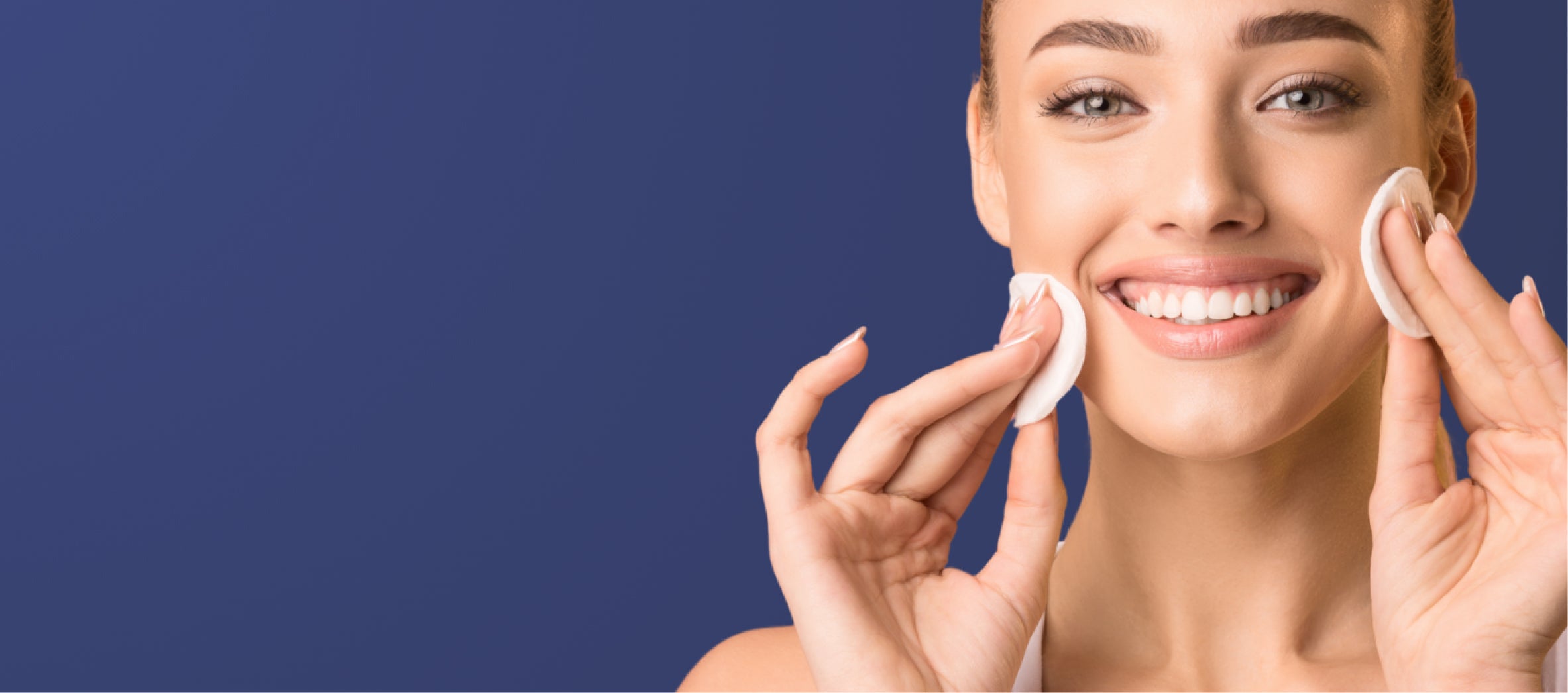 Woman applying cream to her face against a blue background