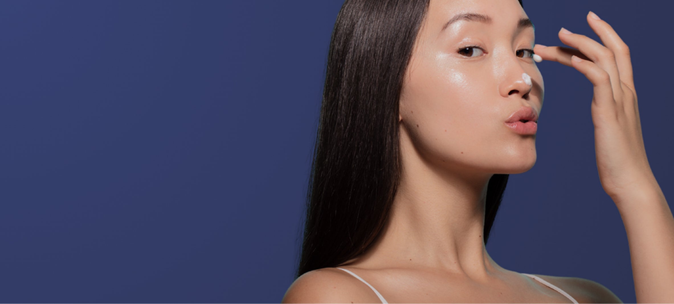 Woman applying makeup with a blue background